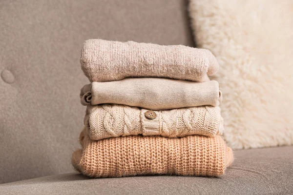 Stack of warm clothes on sofa — Stock Photo, Image