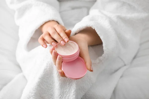 Young woman applying cream on her skin at home, closeup — Stock Photo, Image