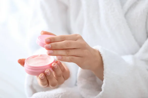 Young woman applying cream on her skin at home, closeup — Stock Photo, Image