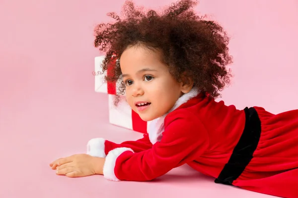 穿着圣诞老人服装的非洲裔美国小女孩，背景是彩色的 — 图库照片