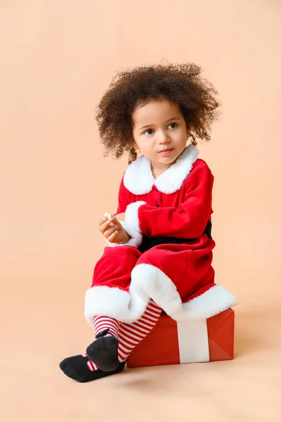 Piccola ragazza afroamericana in costume da Babbo Natale su sfondo di colore — Foto Stock