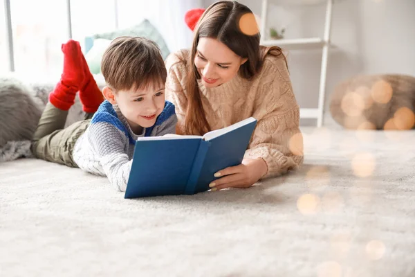 Cute little boy with mother reading book at home — Stock Photo, Image