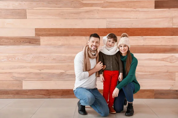 Famiglia felice in abiti invernali su sfondo di legno — Foto Stock