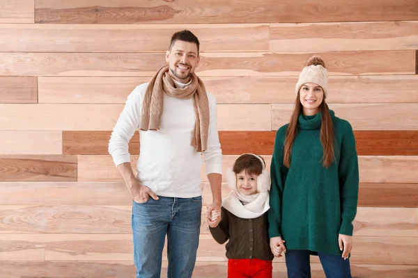 Família feliz em roupas de inverno em fundo de madeira — Fotografia de Stock