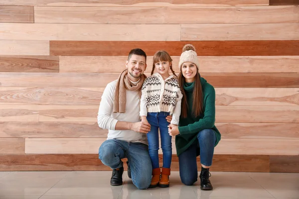Família feliz em roupas de inverno em fundo de madeira — Fotografia de Stock