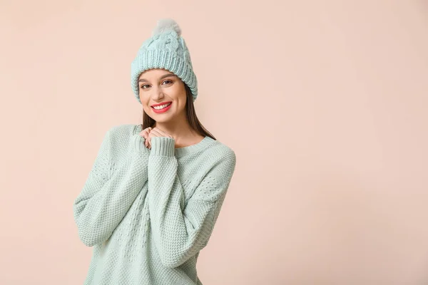 Happy young woman in winter clothes on light background — Stockfoto