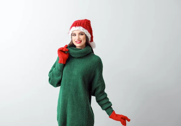 Beautiful young woman in Santa hat on light background — Stock Photo, Image