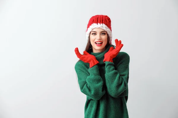 Mooie jonge vrouw in Santa hoed op lichte achtergrond — Stockfoto