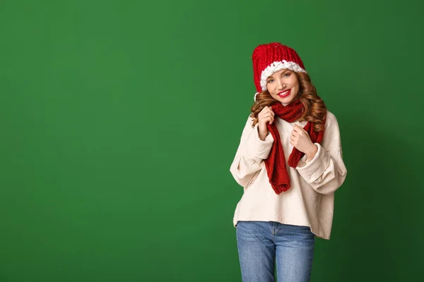 Happy young woman in winter clothes on color background — Stock Photo, Image