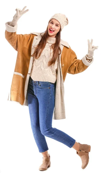 Felice giovane donna in abiti invernali mostrando gesto vittoria su sfondo bianco — Foto Stock