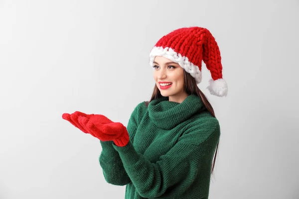 Bella giovane donna a Santa cappello su sfondo chiaro — Foto Stock