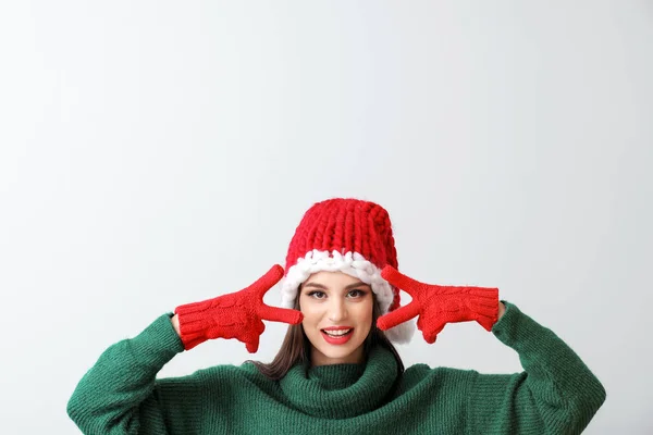 Молодая женщина в шляпе Санта на светлом фоне — стоковое фото