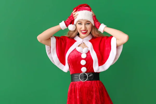 Beautiful young woman dressed as Santa on color background — Stock Photo, Image