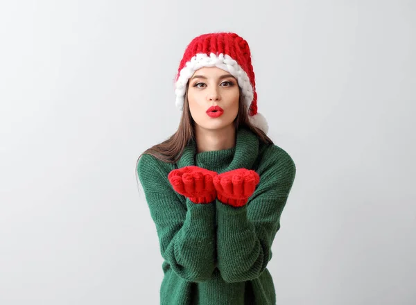 Işıklı arka planda Noel Baba şapkalı güzel bir kadın. — Stok fotoğraf