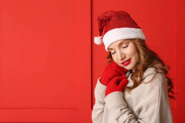 Mladá žena v zimě oblečení na barevném pozadí — Stock fotografie