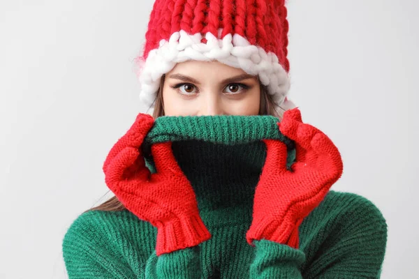 Belle jeune femme en chapeau de Père Noël sur fond clair — Photo