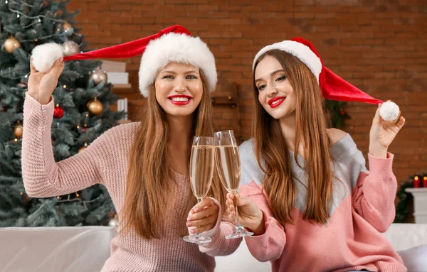 Gyönyörű fiatal nők pezsgővel ünneplik a karácsonyt otthon — Stock Fotó
