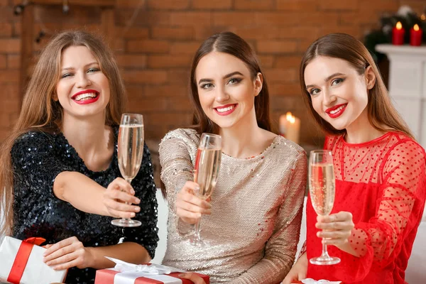 Hermosas mujeres jóvenes bebiendo champán en casa en Nochebuena —  Fotos de Stock