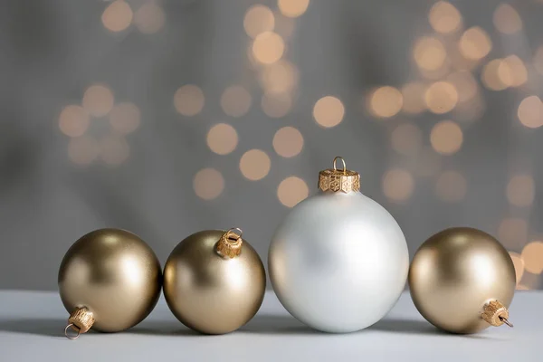 Bulanık ışıklara karşı masada güzel Noel topları — Stok fotoğraf