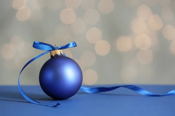 Bela bola de Natal na mesa contra luzes embaçadas — Fotografia de Stock