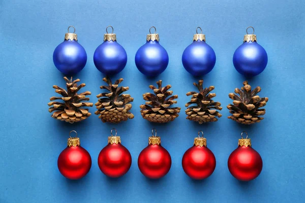 Красивые рождественские шары с конусами на цветном фоне — стоковое фото