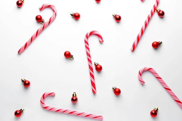 Hermosas bolas de Navidad con bastones de caramelo sobre fondo blanco — Foto de Stock