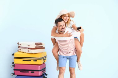 Bavullu çift, arka planda selfie çekiyor.