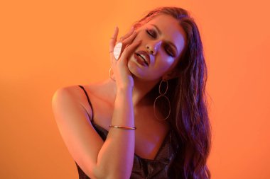 Renkli arka planda zarif genç bir kadının tonlu portresi