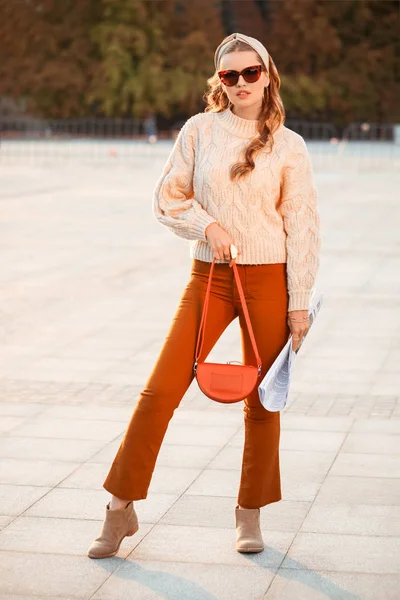 Fashionable young woman with newspaper outdoors — Stockfoto