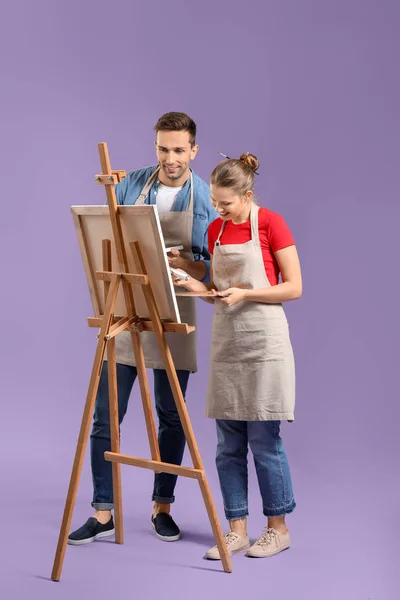 Couple of young artists on color background — Stock Photo, Image