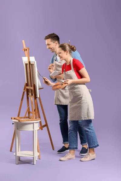 Couple of young artists on color background — Stockfoto