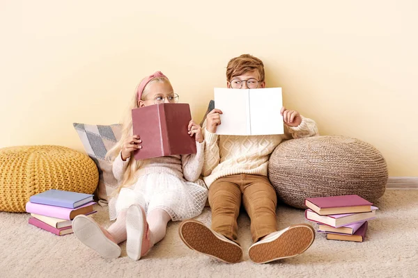 Little children reading books near color wall — Stock Photo, Image