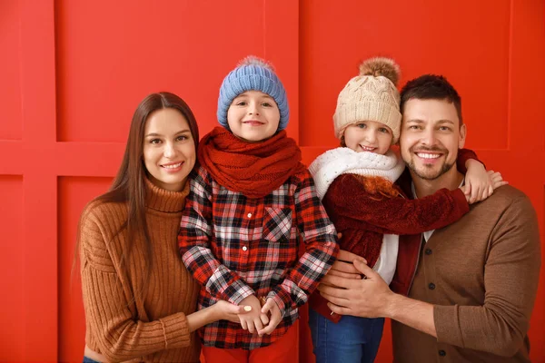 Lycklig familj i vinter kläder på färg bakgrund — Stockfoto