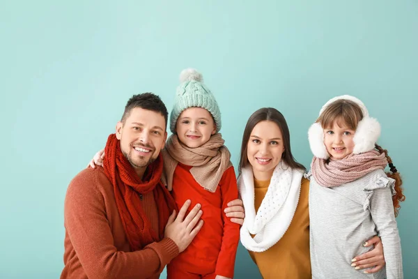 Famille heureuse en vêtements d'hiver sur fond de couleur — Photo