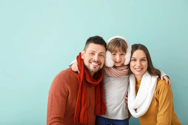 Gelukkig gezin in de winter kleding op kleur achtergrond — Stockfoto