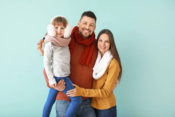 Gelukkig gezin in de winter kleding op kleur achtergrond — Stockfoto