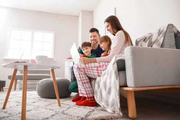 Gelukkig gezin met laptop rustend thuis — Stockfoto
