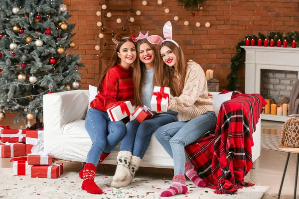 Jovens mulheres bonitas com presentes celebrando o Natal em casa — Fotografia de Stock