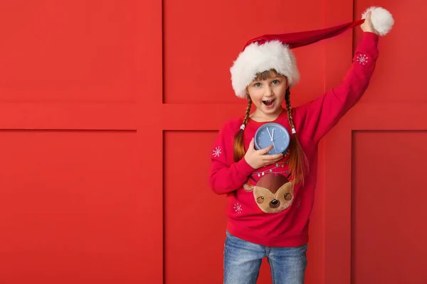 Little girl with alarm clock on color background. Christmas countdown concept — Stock Photo, Image