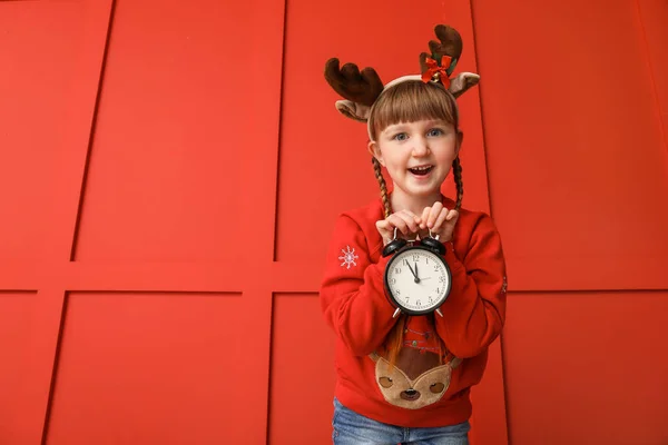Little girl with alarm clock on color background. Christmas countdown concept — Stock Photo, Image