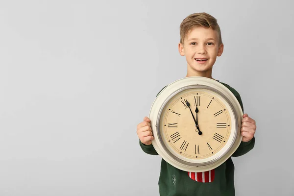 Μικρό αγόρι με ρολόι στο φως φόντο. Χριστούγεννα αντίστροφη μέτρηση έννοια — Φωτογραφία Αρχείου