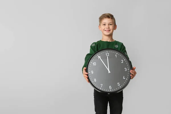 Little boy with clock on light background. Christmas countdown concept — Stock Photo, Image