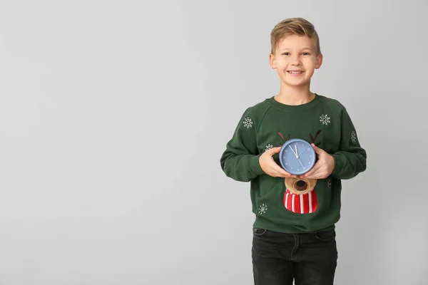 Little boy with alarm clock on light background. Christmas countdown concept — Stock Photo, Image
