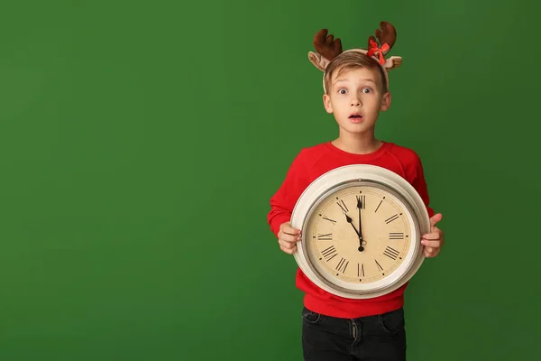 Surprised little boy with clock on color background. Christmas countdown concept — Stock Photo, Image