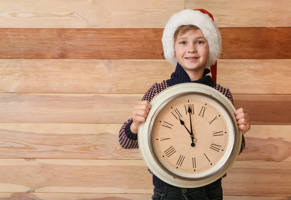 Μικρό αγόρι με ρολόι σε ξύλινο φόντο. Χριστούγεννα αντίστροφη μέτρηση έννοια — Φωτογραφία Αρχείου