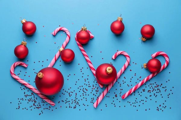 Hermosas bolas de Navidad y bastones de caramelo en el fondo de color — Foto de Stock