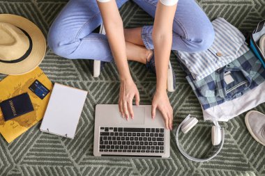 Dizüstü bilgisayarlı bir kadın seyahat acentesini ziyaret ediyor.