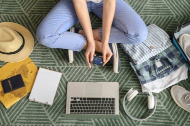 Dizüstü bilgisayarlı bir kadın seyahat acentesini ziyaret ediyor.