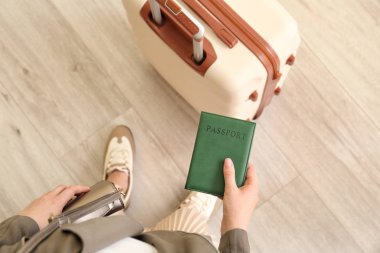 Evinde bavulu ve pasaportu olan genç bir kadın.