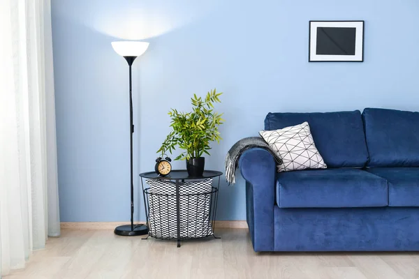 Interior of modern room with blue sofa and table near color wall — Stock Photo, Image